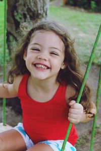 Portrait of smiling girl playing with swing