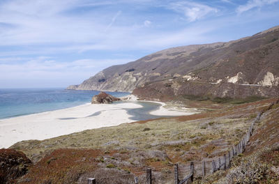 Scenic view of sea and mountains against sky