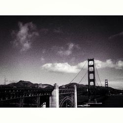 Low angle view of bridge against cloudy sky