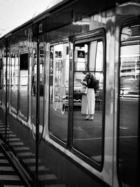 Rear view of woman on train at railroad station