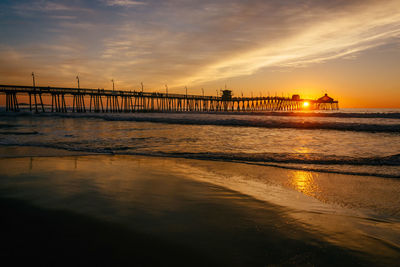 Pier over sea against sky during sunset