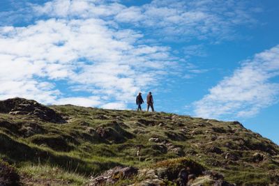 People on mountain against sky