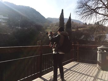 Rear view of men standing on railing