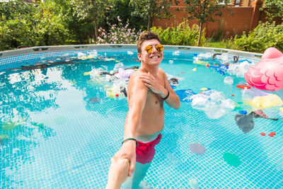 Full length of a smiling young woman swimming pool