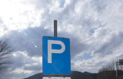 Low angle view of information sign against sky