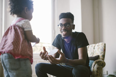 Young man playing with daughter at home