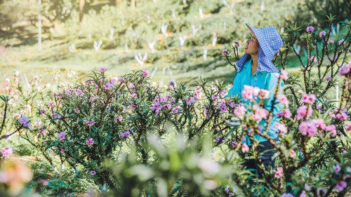 Female researcher standing amidst flowers on land