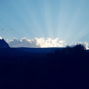 Silhouette landscape against cloudy sky