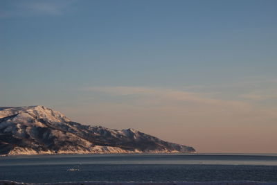 Scenic view of sea and mountains against sky