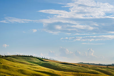 Scenic view of field and hills against sky in tuscany