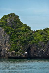 Scenic view of rocks by sea against sky