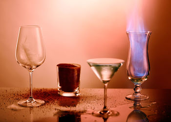 Close-up of ground coffee with feather and flame in glass on table