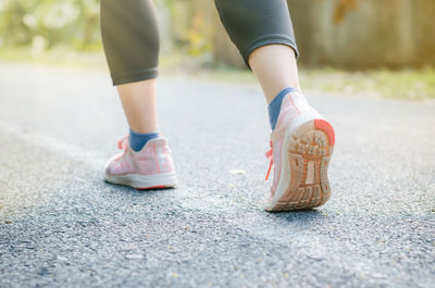 Low section of woman standing on footpath