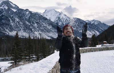 Man playing with snow against mountain