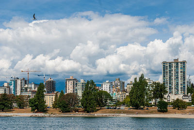 Buildings by sea against sky in city