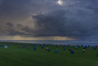 People playing on beach against sky