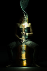Digital composite image of man sitting in darkroom