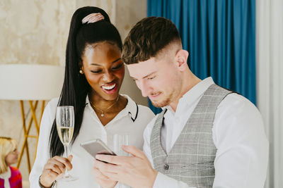 Businessman sharing smart phone with female colleague during event at convention center