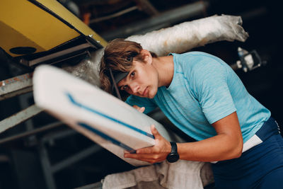 Portrait of man holding canoe