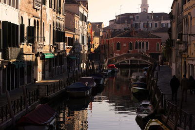 Boats moored by buildings in city