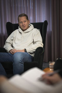 Man sitting in armchair at therapy session