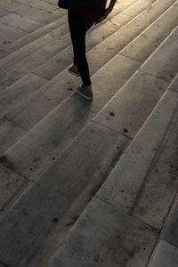 Low section of woman walking on footpath