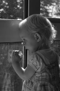 Side view of a little girl gazing out of window