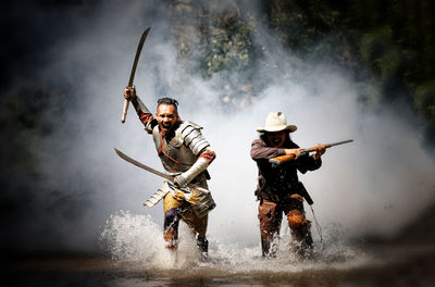 Portrait of hunters running in against smoke 