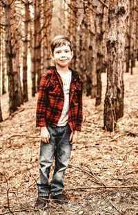 A boy walks in the woods. red shirt and jeans