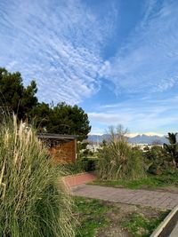 View of footpath by building against sky
