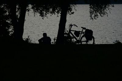 Silhouette people in water at sunset