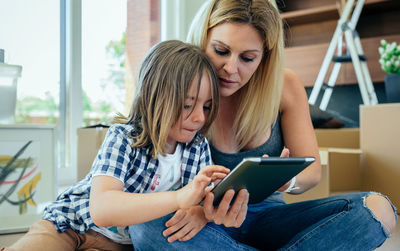 Mother with son using digital tablet at home