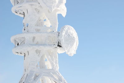 Low angle view of icicles against clear blue sky