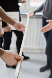 Close-up of couple with real estate agent measuring in new house
