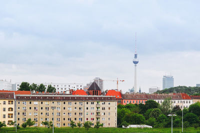 Mid distance view of fernsehturm against sky in city