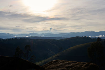 Scenic view of  volcanic activity against sky during sunrise