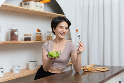 Portrait of young woman sitting on table