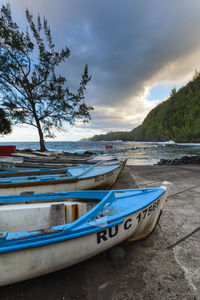 Boat moored on beach against sky