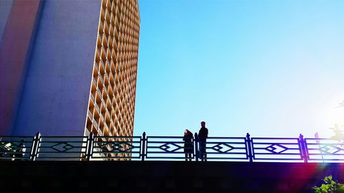 Low angle view of woman standing against clear sky