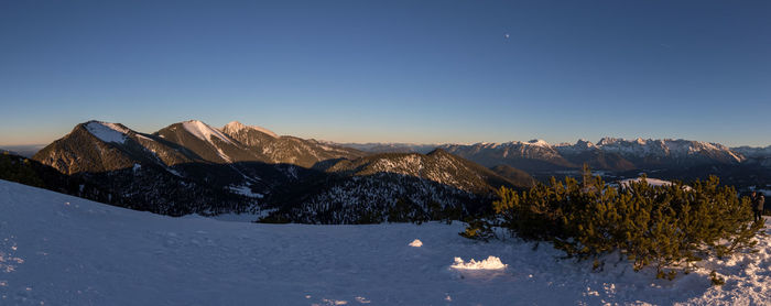 Scenic view of snowcapped mountains against clear blue sky