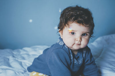 Cute baby girl on bed at home