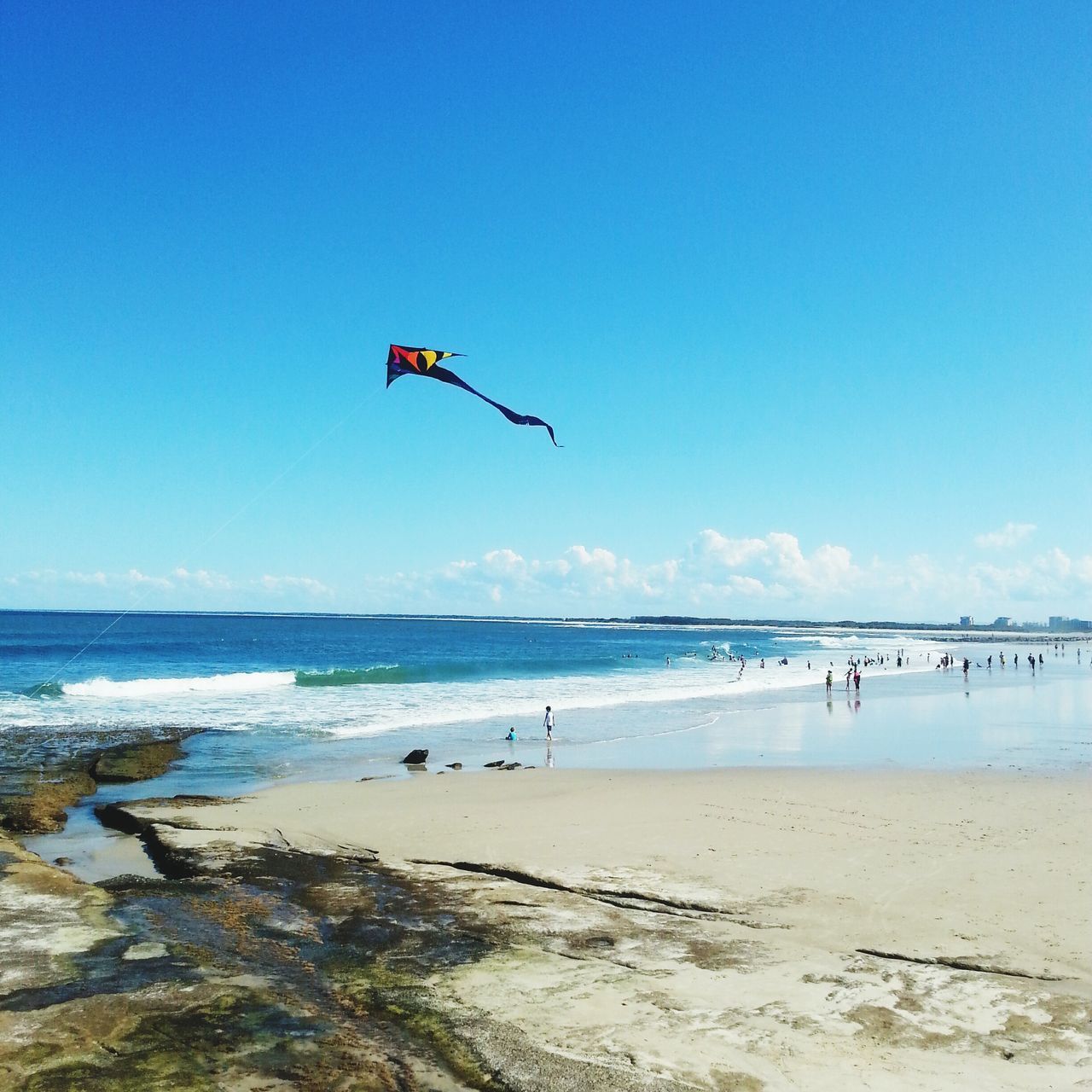 sea, beach, flying, leisure activity, mid-air, water, vacations, blue, lifestyles, extreme sports, sand, shore, parachute, adventure, horizon over water, scenics, enjoyment, clear sky, sky