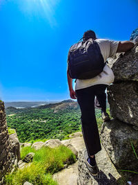 Rear view of man standing on rock