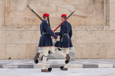 Rear view of men standing against wall