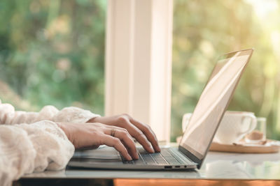Midsection of man using laptop on table
