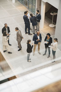 High angle view of male and female professionals talking outside office