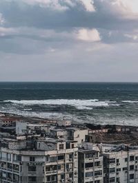 High angle view of buildings by sea against sky