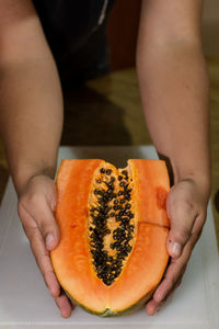 Midsection of man holding fruit