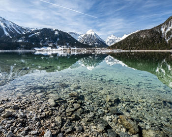 Scenic view of lake and snowcapped mountains against sky