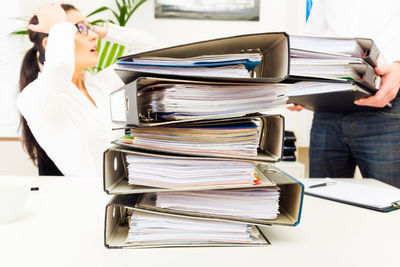 Rear view of woman working on shelf